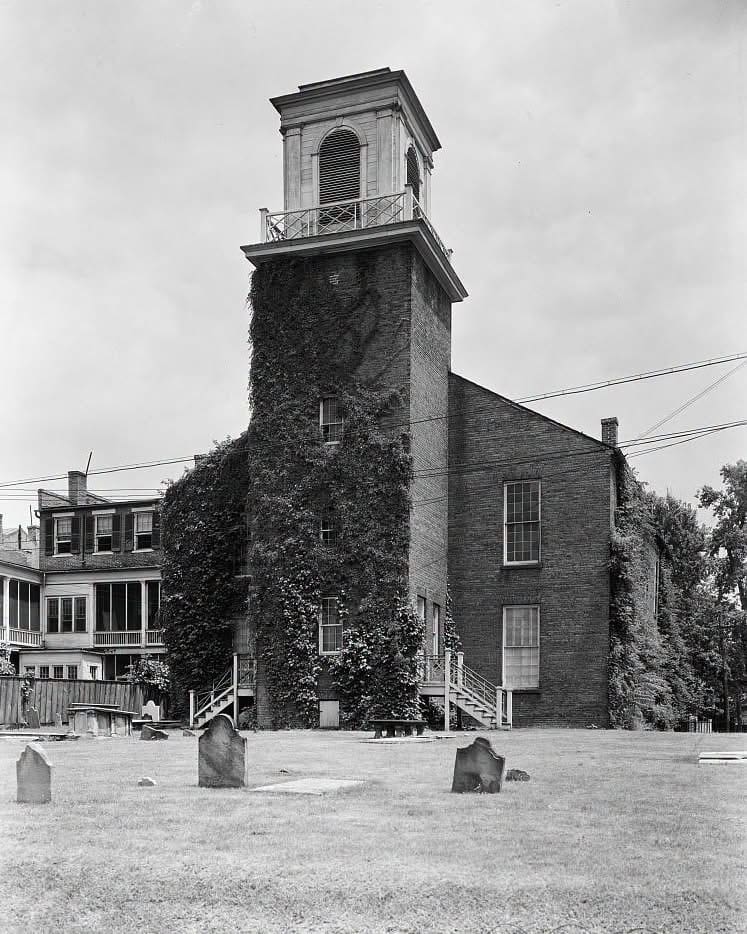 The Old Presbyterian Meeting House and burial ground in Alexandria, Virginia, with the townhouse beyond the wooden fence on the northern boundary.